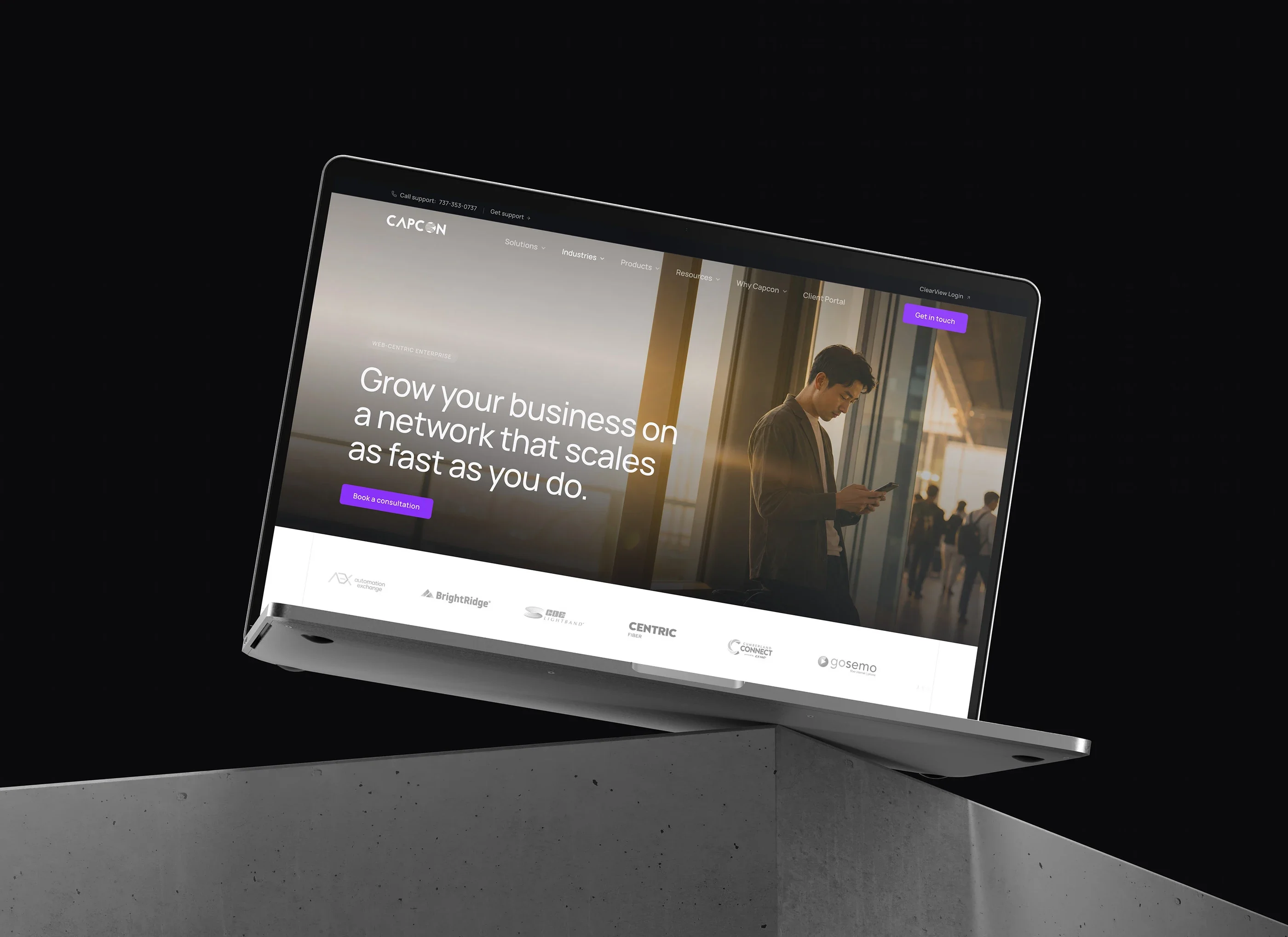 The web-centric enterprise page on a laptop against a dark background: 'Grow your business on a network that scales as fast as you do.'
